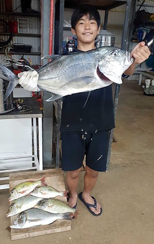 16日、恩納村海岸で80センチのロウニンアジと、50センチのタマン他ムネアカなどを釣った二俣虎太郎さん
