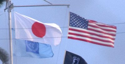 米軍普天間飛行場に掲げられる日米の国旗と国連旗＝2023年12月26日、宜野湾市
