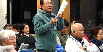 訪問税に関する住民説明会で町側に質問する参加者＝1月26日、竹富島のまちなみ館