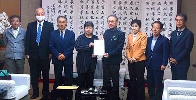 玉城デニー知事（右から4人目）にうるま市石川のゴルフ場跡地への自衛隊訓練場新設計画断念を求める意見書を手渡す石川地区自治会長連絡協議会の與古田ゆかり会長（同5人目）＝16日、県庁