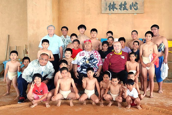 ミュージアム伊江島営業所6周年記念イベントで相撲を指導したKONISHIKIさんら＝5日、伊江中学校相撲場