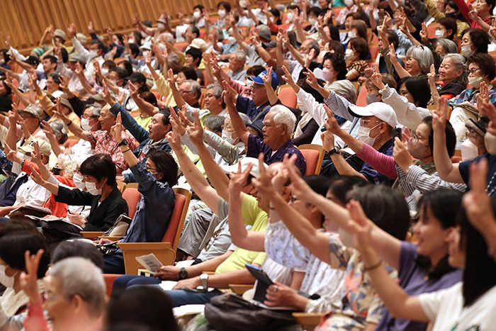 在沖縄ミャンマー人会からの呼びかけに応じて「抵抗」を示す3本指を立てる来場者たち