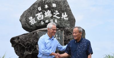 与那国町を訪れ、日本最西端の碑の前で糸数健一町長（右）と握手するエマニュエル駐日米大使＝17日