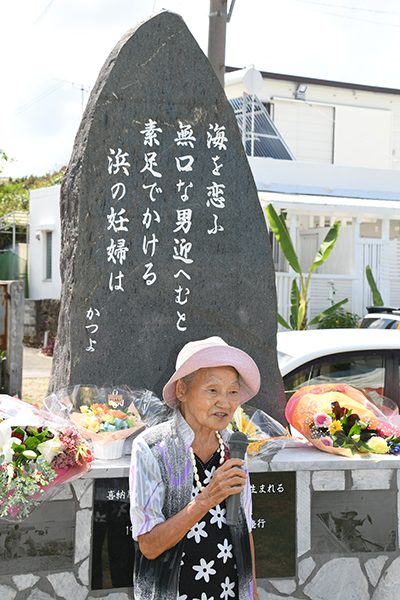 建立された歌碑を背に「糸満の誇りを若い世代に引き継いでほしい」と語る喜納勝代さん