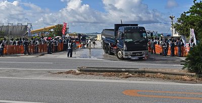 土砂を降ろし国道に出るダンプ＝22日、名護市安和（ジャン松元撮影）