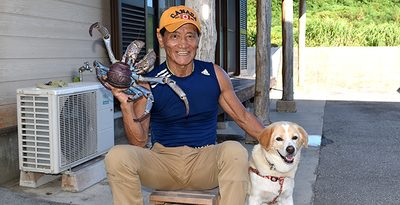 巨大ヤシガニを捕まえた當真嗣満さんと愛犬ハッチ－＝8月1日、うるま市勝連平安名