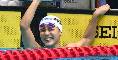 女子50メートル自由形決勝　タイムを確認し、笑顔でガッツポーズをする平良吏美華（那覇西）＝18日、佐賀県のSAGAサンライズパークSAGAアクア（屋嘉部長将撮影）